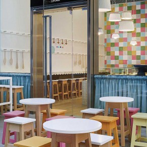 Interior Design for a Cupcake Shop with pink, orange and white table in front shop